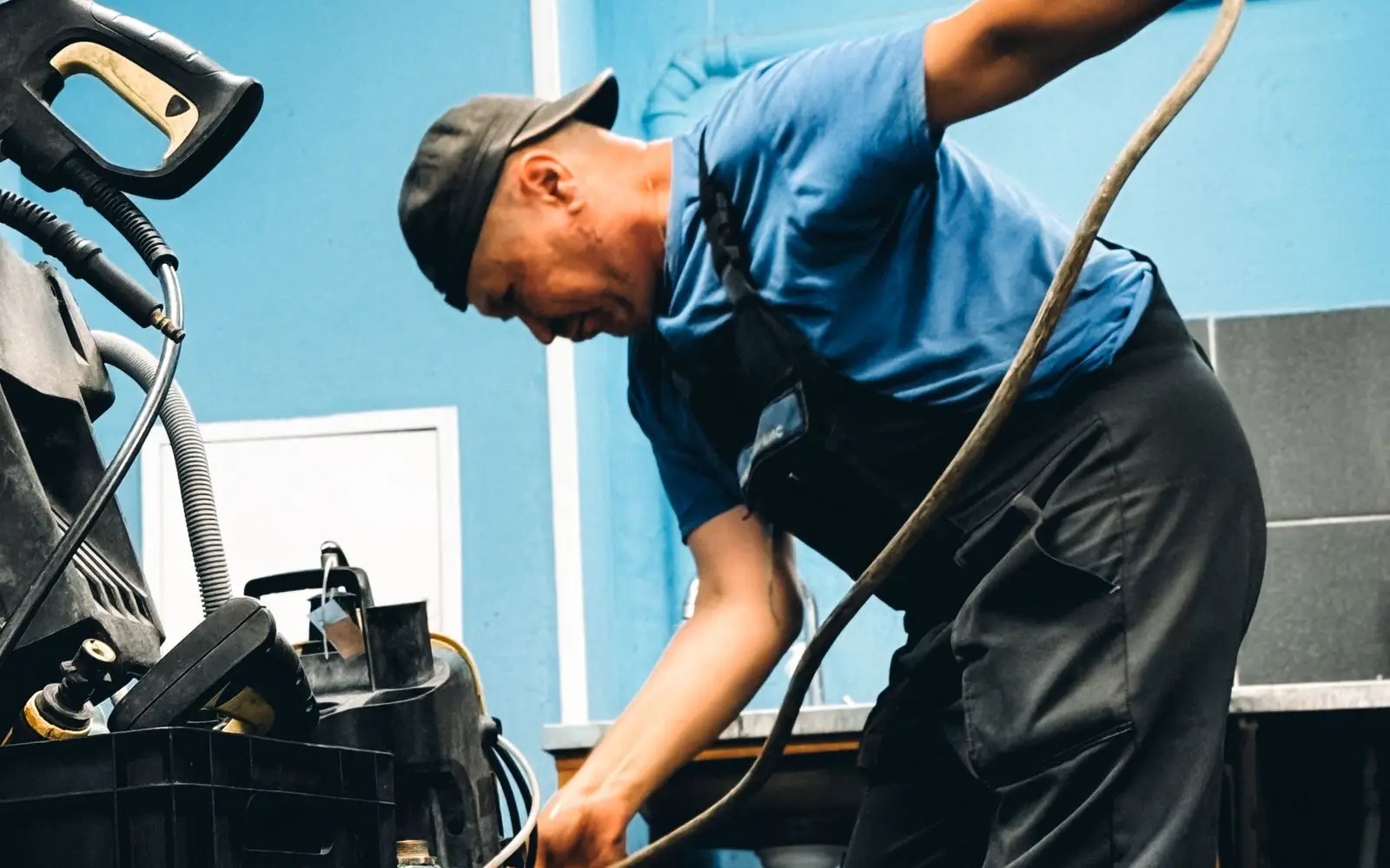 A drain technician at work with jetting equipment and a hose