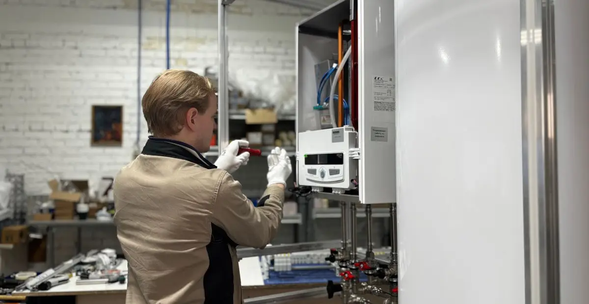 A technician servicing equipment on a wall