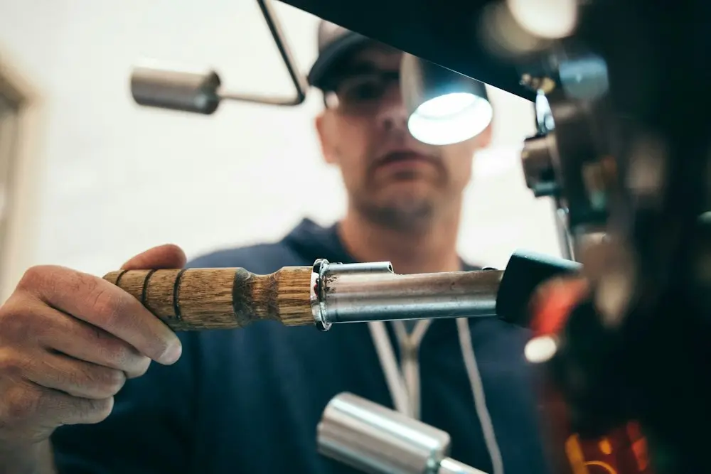 A technician with a large wrench and head torch