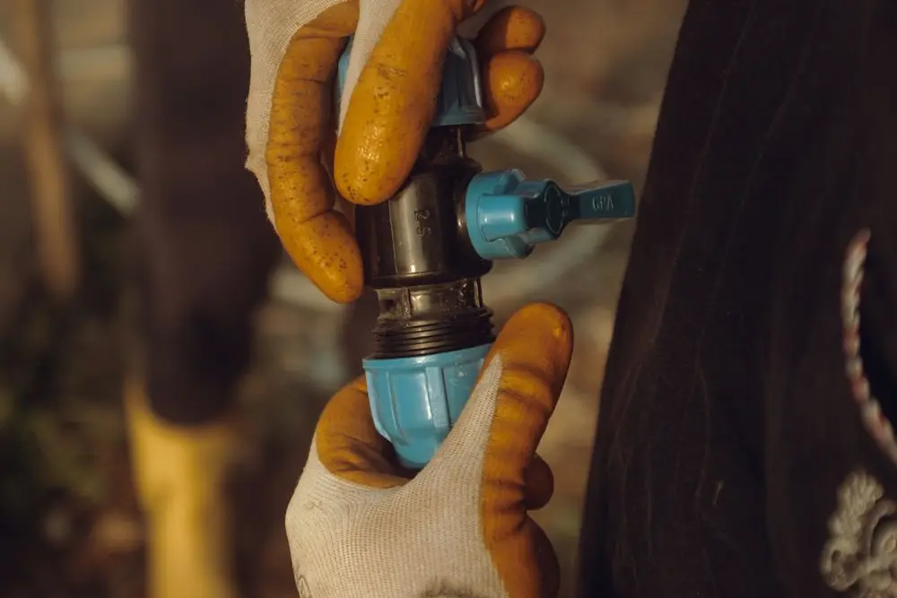 Gloved hands fitting a pipe coupling