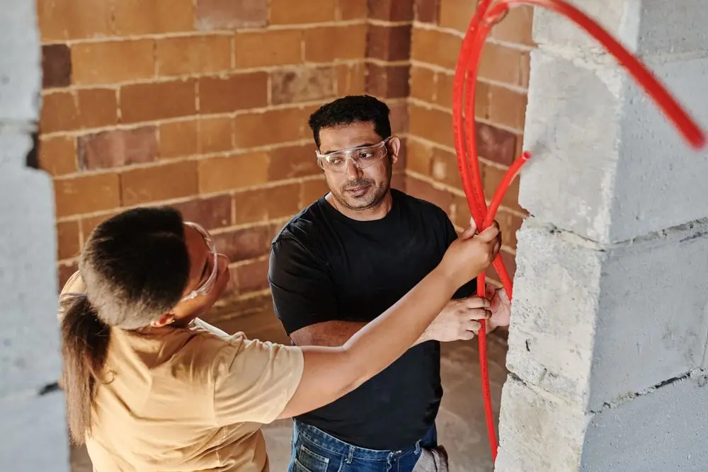 Two workers fitting pipework on a job